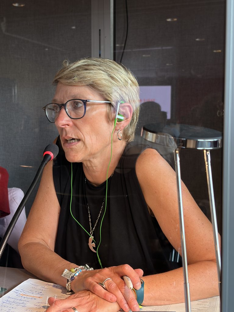 Translingua Dolmetscherin mit Mikrofon, Headset und Fachunterlagen im Dolmetsch-Einsatz